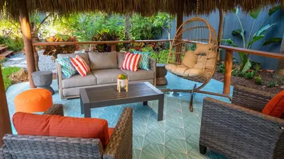 a patio with a couch and chairs and a table at Villa Tropical - Your private Miami Resort with a heated pool in North Miami