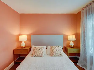 a bedroom with orange walls and a bed with two lamps at Luxury Miami Casa Bonita with Tropical Pool Oasis in Miami