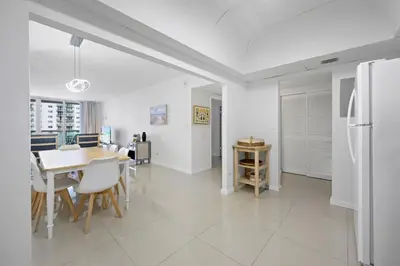 a kitchen and dining room with a table and a refrigerator at Beautiful and big Apartment by the beach in Sunny Isles Beach