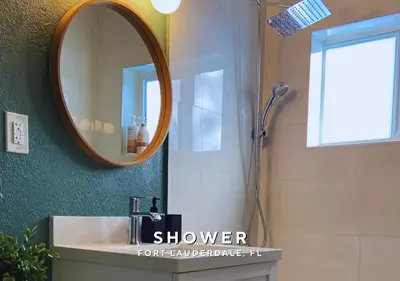 a bathroom with a sink with a mirror and a shower at Private Heated Plunge Pool Spa and Secluded Patio - Fort Lauderdale in Fort Lauderdale