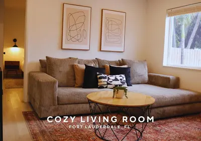 a living room with a brown couch and a table at Private Heated Plunge Pool Spa and Secluded Patio - Fort Lauderdale in Fort Lauderdale