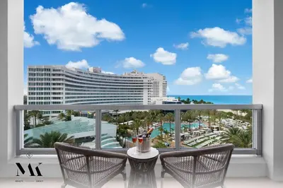 a balcony with a view of the ocean and a hotel at FountaineBleau Resort, Balcony with Ocean & Pool View in Miami Beach