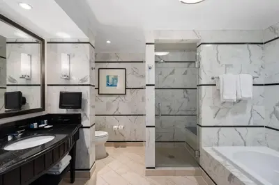 a bathroom with two sinks and a tub and a toilet at FountaineBleau Resort, Balcony with Ocean & Pool View in Miami Beach