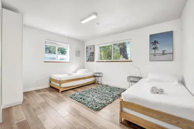 a white bedroom with two beds and a rug at Private Waterfront Paradise in Hollywood