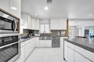 a kitchen with white cabinets and stainless steel appliances at Private Waterfront Paradise in Hollywood