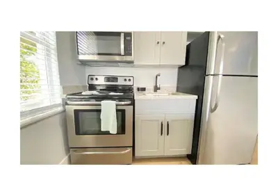 a kitchen with a stainless steel stove and refrigerator at Cozy Duplex near Wynwood & Beach in Miami