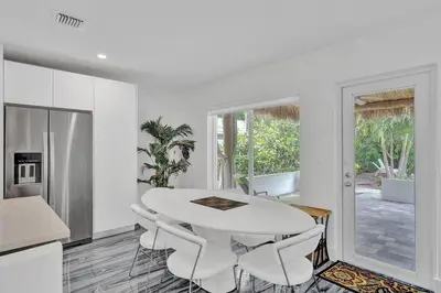 a kitchen and dining room with a white table and chairs at Daddy House-victoria Park With Pool in Fort Lauderdale