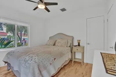 a bedroom with a bed with a ceiling fan and a window at Daddy House-victoria Park With Pool in Fort Lauderdale