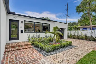 a white house with a palm tree in front of it at Hibiscus House in Fort Lauderdale