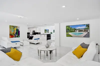 a living room with white furniture and yellow pillows at Hibiscus House in Fort Lauderdale