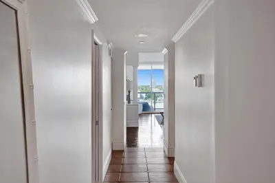 a hallway leading to a kitchen with white walls at Le Petit Italie ,water View 22 With Pool in Sunny Isles Beach