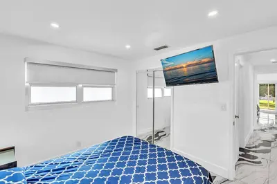 a bedroom with a blue bed and a flat screen tv at waterfront Ocean dream House Hollywood Hard Rock airport in Fort Lauderdale