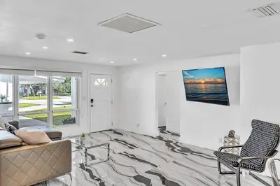a living room with a couch and a tv on a wall at waterfront Ocean dream House Hollywood Hard Rock airport in Fort Lauderdale