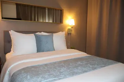 a large bed in a hotel room with a mirror at Hotel TB Downtown Miami in Miami