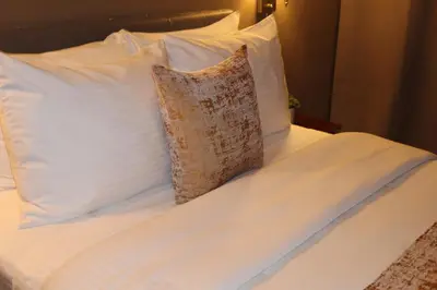 a bed with white sheets and a pillow on it at Hotel TB Downtown Miami in Miami