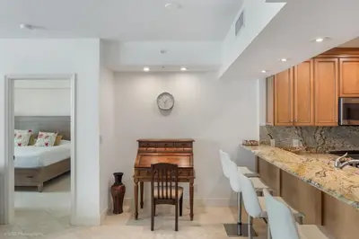 a kitchen with a desk and a bedroom with a bed at Modern 2 BDR at King David with Ocean View in Sunny Isles Beach