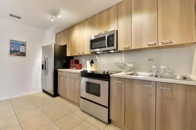 a kitchen with a stainless steel refrigerator and a sink at Wynwood Area with Hot Tub, 10 min from South Beach in Miami