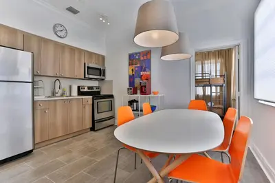 a kitchen with a white table and orange chairs at 3 Bedroom Apartment with BBQ and Patio, Near Brickell in Miami