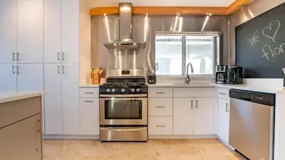 a kitchen with white cabinets and a stove top oven at Winter Rate Discount Beachside Home Pool Views Beach Haven by AvantStay in Fort Lauderdale