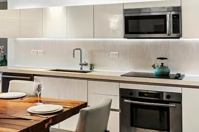 a kitchen with a wooden table and a microwave at Oceanview Private Condo at 1 Hotel & Homes -1222 in Miami Beach