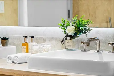 a bathroom sink with a vase of flowers on it at Oceanview Private Condo at 1 Hotel & Homes -1222 in Miami Beach