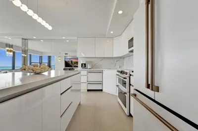 a kitchen with white cabinets and white appliances at Beautiful Oceanfront 3BDR Condo 801 in Miami Beach