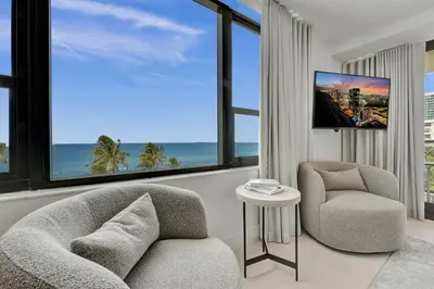 a living room with a couch and a chair and windows at Beautiful Oceanfront 3BDR Condo 801 in Miami Beach