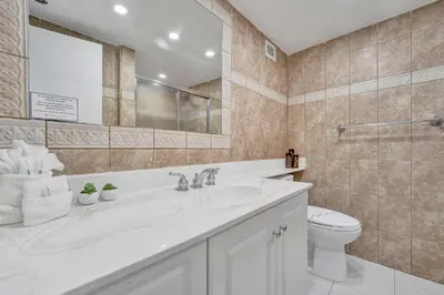a bathroom with a sink and a toilet and a mirror at Oceanfront Beach Retreat Beach Service 905 in Miami Beach