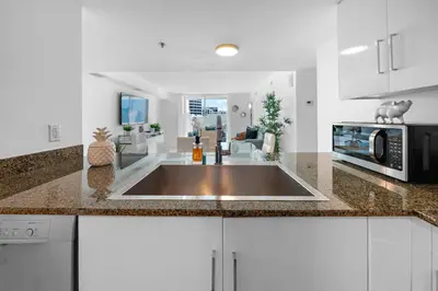 a kitchen with a sink and a microwave at Stylish 2BR With Skyline Views, Free Parking, Sleeps 8 in Miami
