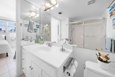 a white bathroom with a sink and a mirror at Stylish 2BR With Skyline Views, Free Parking, Sleeps 8 in Miami