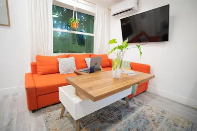 a living room with an orange couch and a table at Cozy Tiny Home - Hidden Gem! in Miami