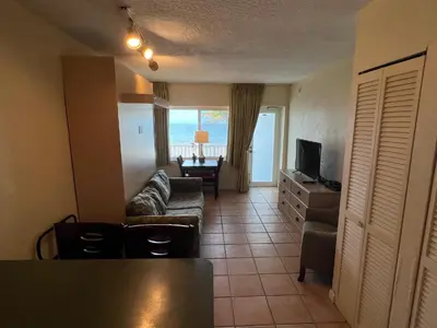 a living room with a couch and a television at Enchanted Isle Hollywood Beach Resort in Hollywood