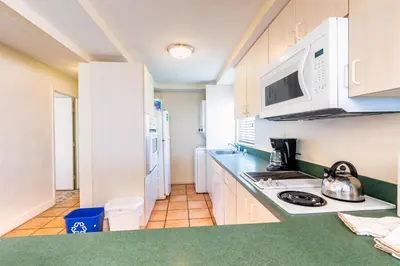a kitchen with white cabinets and a stove top oven at Enchanted Isle Hollywood Beach Resort in Hollywood