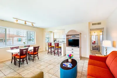 a living room with a couch and a table and a kitchen at Enchanted Isle Hollywood Beach Resort in Hollywood