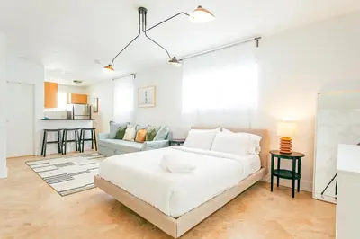 a white bedroom with a bed and a couch at Spacious Apt in the heart of South Beach in Miami Beach