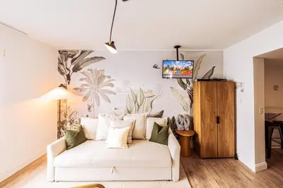 a living room with a white couch and a tv on a wall at Amazing studio in Ocean Drive in Miami Beach