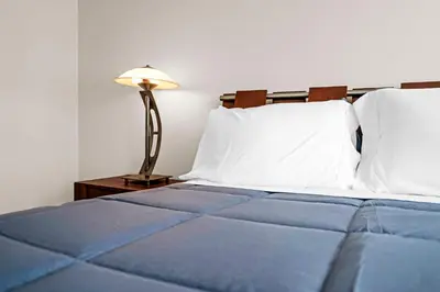 a bed with blue sheets and a lamp on a table at 2 Bedrooms Unit OceanFront Resort The Alexander in Miami Beach