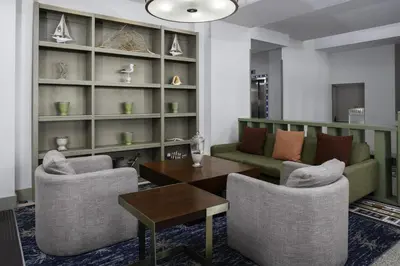 a living room with a couch and chairs and a table at Hilton Garden Inn Miami South Beach in Miami Beach