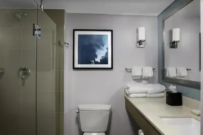 a bathroom with a toilet and a shower and a sink at Hilton Garden Inn Miami South Beach in Miami Beach