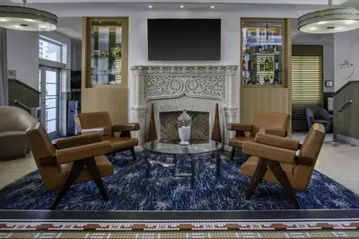 a lobby with a fireplace and chairs and a tv at Hilton Garden Inn Miami South Beach in Miami Beach