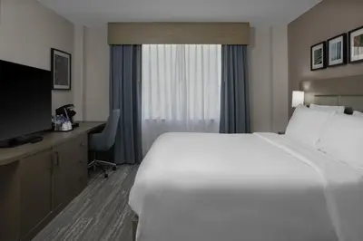 a hotel room with a large white bed and a desk at Hilton Garden Inn Miami South Beach in Miami Beach