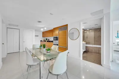 a dining room with a glass table and white chairs at Unique 1BR Icon Brickell WaterViews-Freespa in Miami