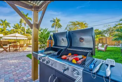 a blue barbecue grill with food inside of it at Coastal Paradise Retreat- Mini Golf, 4 Bedrooms, Game Room, Htd Pool, BBQ Fire Pit in Hollywood