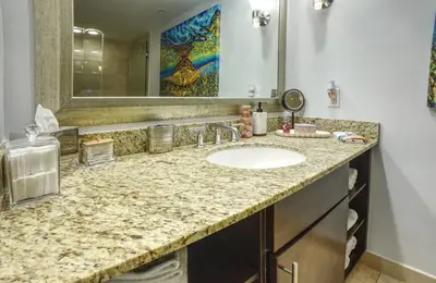 a bathroom with a sink and a mirror at GalleryOne Doubletree Hilton GC Turtle Cove in Fort Lauderdale