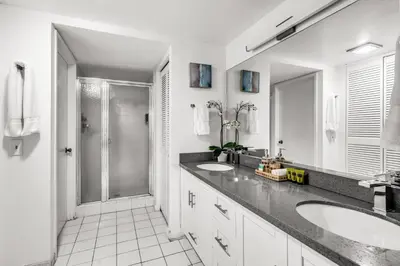 a bathroom with two sinks and a shower at Tropical Retreat with Beach Resort Amenities in Miami
