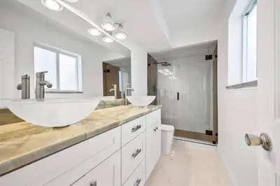 a white bathroom with two sinks and a shower at Inactive 193 Modern, 4B&3B with Pool and Lake in Pembroke Pines