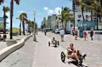 a group of people sitting on a bike on a sidewalk at Beautiful Tropical Vacation House close to Beach in Hollywood