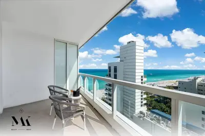 a balcony with a chair and a view of the ocean at FontaineBleau, Balcony w Ocean plus Bay and City View in Miami Beach