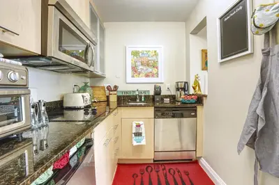 a kitchen with white walls and a red rug at GalleryOne Doubletree Hilton GC Secret Blending in Fort Lauderdale
