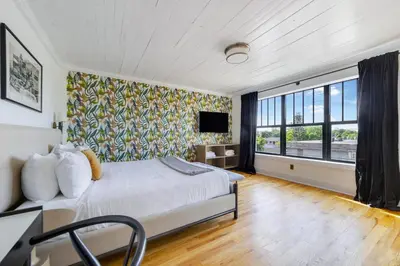a bedroom with a bed and a large window at Tower Hotel Little Havana in Miami